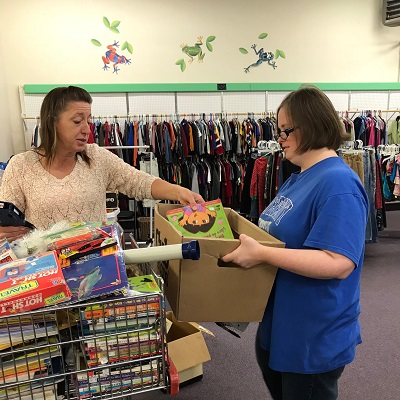 Baby Steps manager Sherry helps worker Amy sort books.