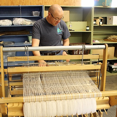 An employee working the loom at STEP Browerville